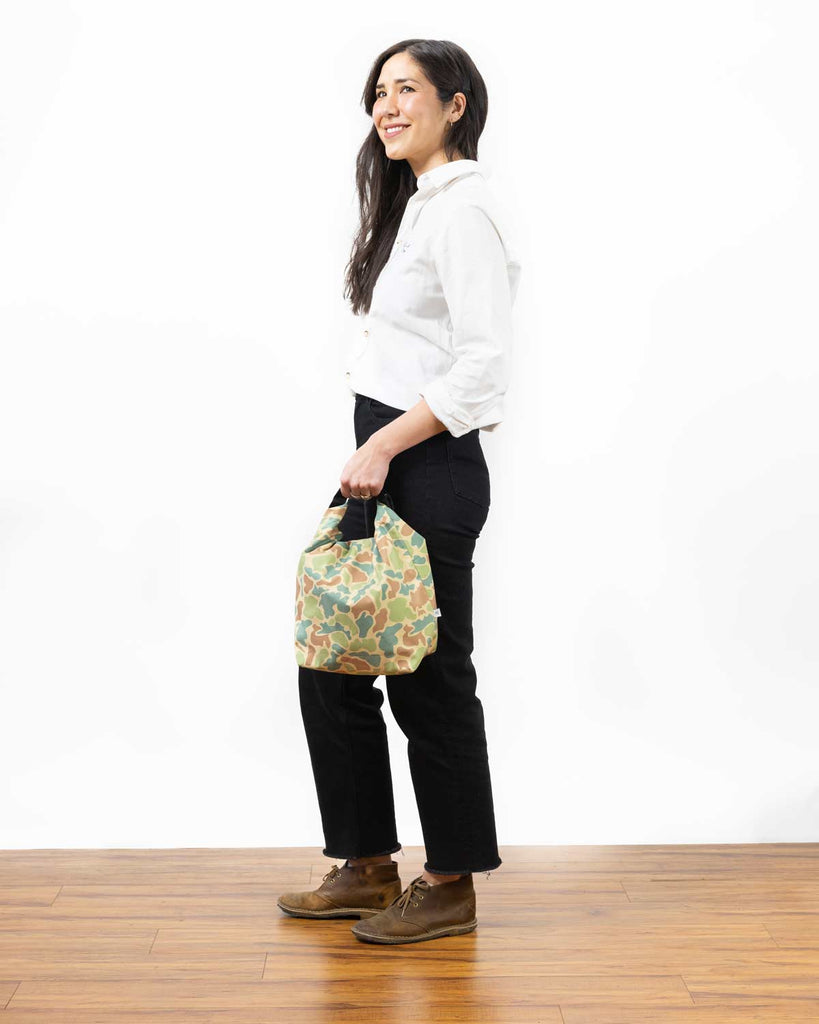 camo lunch bag being held by a smiling woman